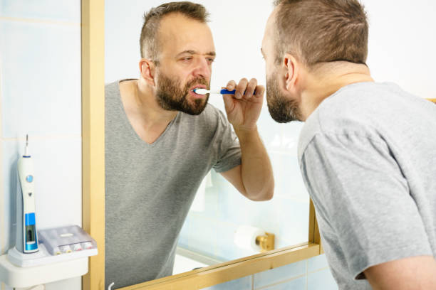 istock Man brushing his teeth in bathroom 1156272785