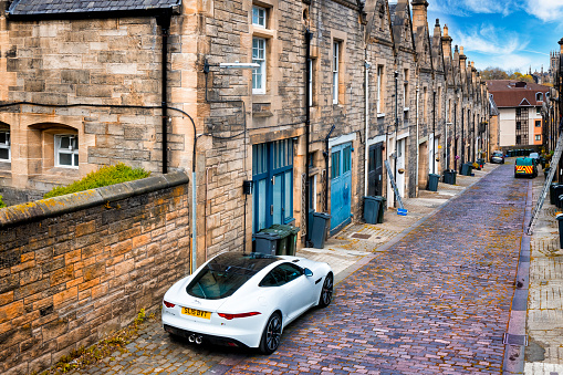Edinburgh, United Kingdom - May 10, 2019:A modern white Jaguar F-Type S against the backdrop of the old Victorian buildings of the old city in Edinburgh, Scotland, UK