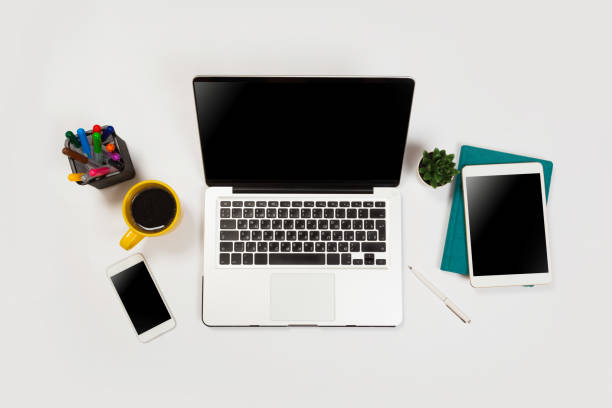 istock Modern workspace with coffee cup, smartphone, paper, notebook, tablet and laptop copy space on white color background. Top view. Flat lay style. 1156280805