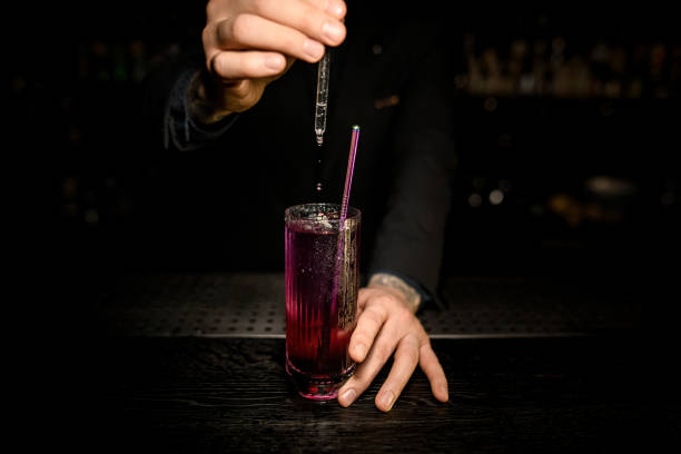 istock Male Bartender finishing a cocktail with dropper 1156285468