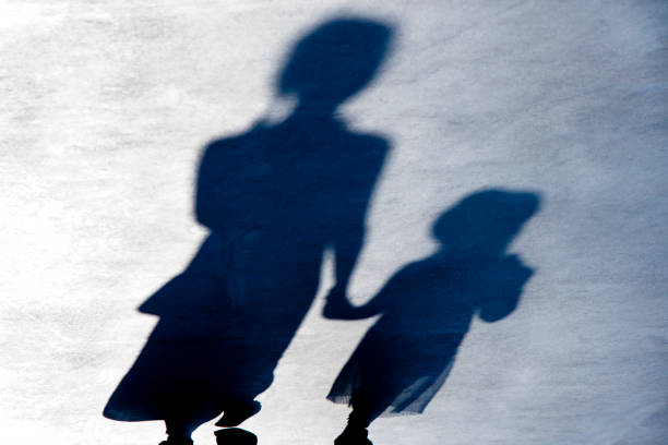 Blurry vintage shadows silhouettes of two person walking  in the night Blurry vintage shadows silhouettes of two female person walking  in black and white night mom and sister stock pictures, royalty-free photos & images