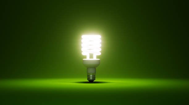 緑色の背景に光る省エネ電球 - 電球形蛍光灯 ストックフォトと画像