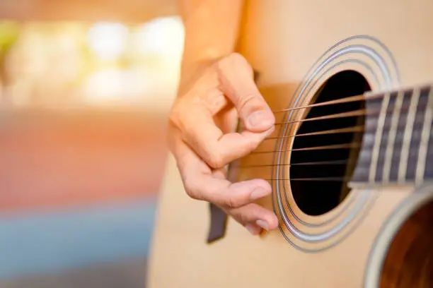 Photo of Musician playing guitar classic and singing song, close up hand