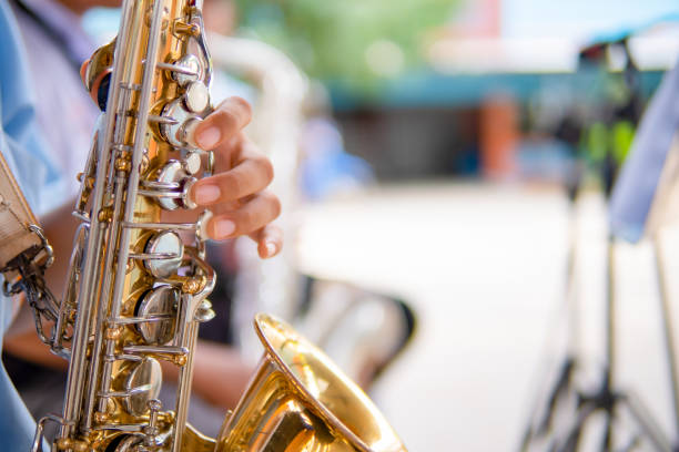 istock Hand holding and playing saxophone on blurred background 1156288784
