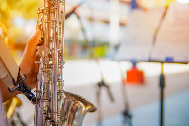 istock Hand holding and playing saxophone on blurred background 1156288867