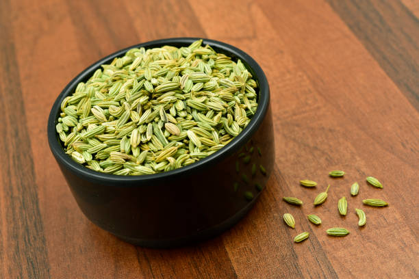 istock Fennel seeds in a black bowl on wooden table. 1156290208