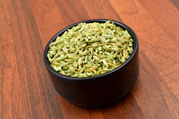 fennel seeds in a blacl bowl on wooden table. - ingredient fennel food dry imagens e fotografias de stock