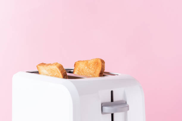 istock White toaster with  roasted toast bread on pink background, close up 1156290256