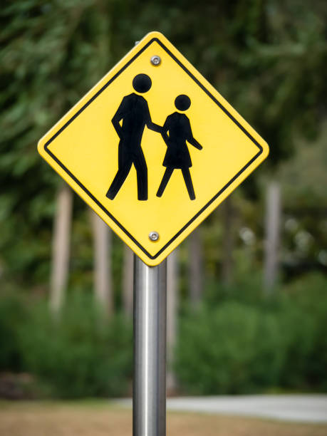 istock Sign at pedestrian crossing with people walking 1156296399