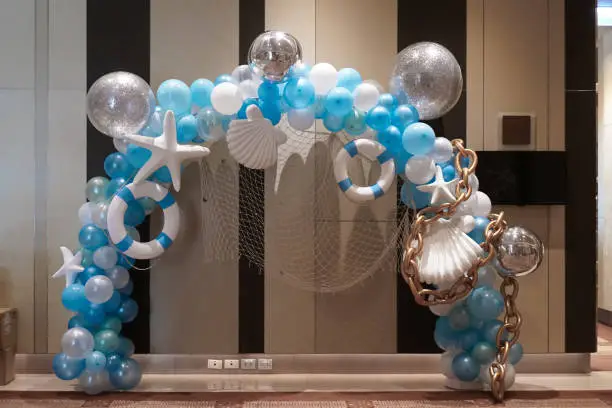 Photo of Balloons in sea and summer concept. Blue and white balloons for interior decoration with starfish, life buoy and seashell. Soft focus.