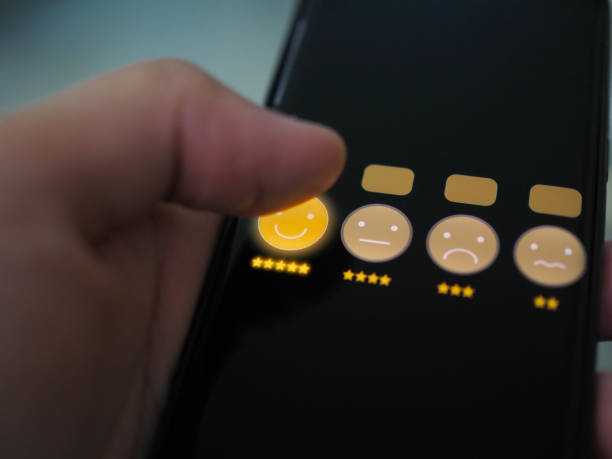 istock hand holding smartphone with customer service and smile face icon on screen 1156300037
