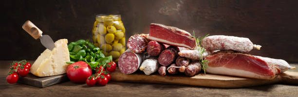 italian food. various kind types of salami, speck, sausages, parmesan cheese, olives, basil and fresh tomatoes - italian cuisine minced meat tomato herb imagens e fotografias de stock
