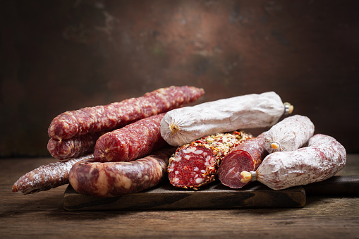 Various kind types of salami and sausages on a wooden board