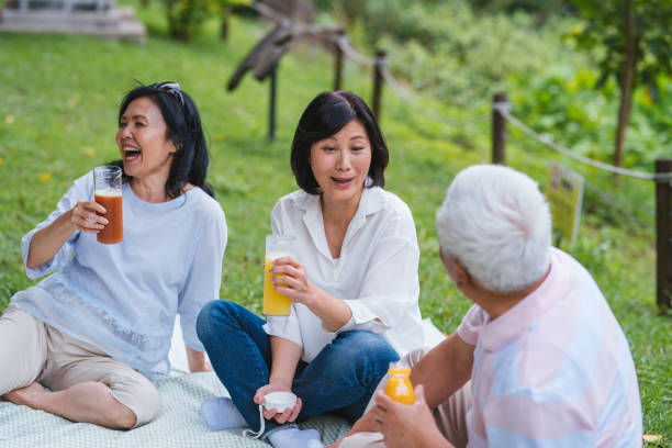istock Three Asia Senior Retirement Having Picnic In Park Concept 1156301604