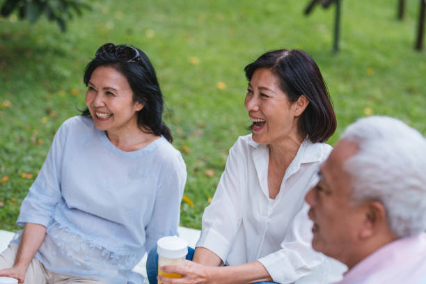 istock Three Asia Senior Retirement Having Picnic In Park Concept 1156301703