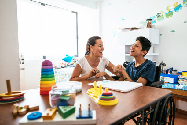 istock Latina mother teaching her son with Celebral Palsy basic skills 1156301918