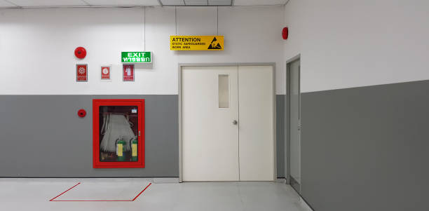 istock Fire exit way door and fire exit sign lightbox and fire hose in electronic industry ,Green emergency exit sign door direction in case of emergency signage,Fire safety symbol and fire protection. 1156302683