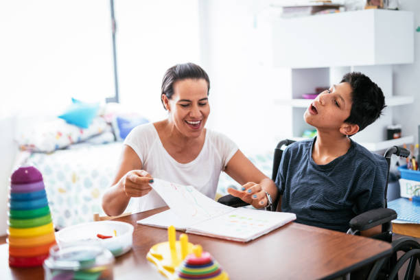 istock Mother teaching her son with Celebral Palsy how to draw 1156302982