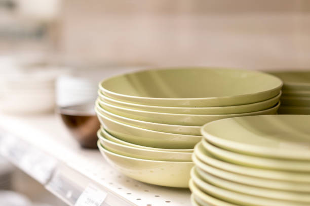 istock Olive-colored flat dishes on the shelf in the store 1156303045