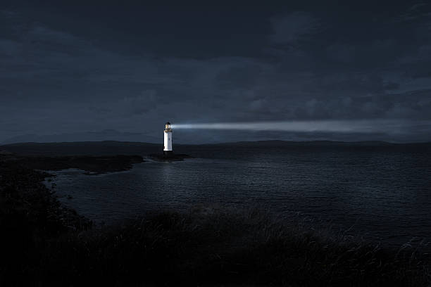 Lighthouse Light house at night projecting a powerful beam into the night to guide those who are lost searchlight photos stock pictures, royalty-free photos & images