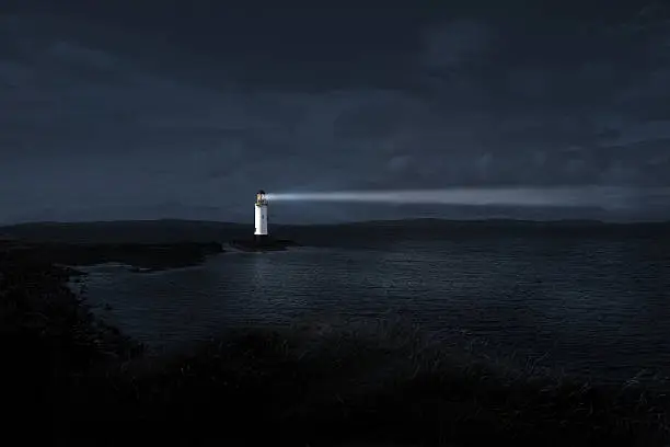 Light house at night projecting a powerful beam into the night to guide those who are lost