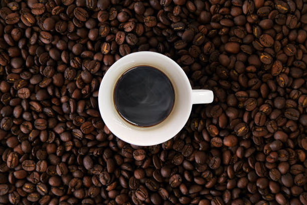 istock Warm cup of coffee with coffee beans background 1156304715