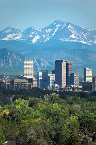The snow covered Rocky Mountains and Longs Peak rises over the Boulder Flatirons and Downtown Denver skyscrapers, hotels, office and apartment buildings.