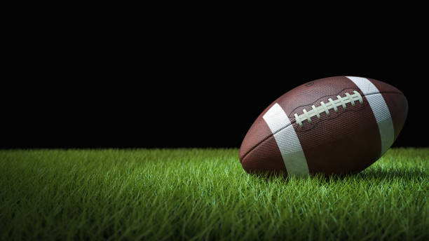 American football on green grass, on black background American football on green grass, on black background - 3D illustration evening ball stock pictures, royalty-free photos & images