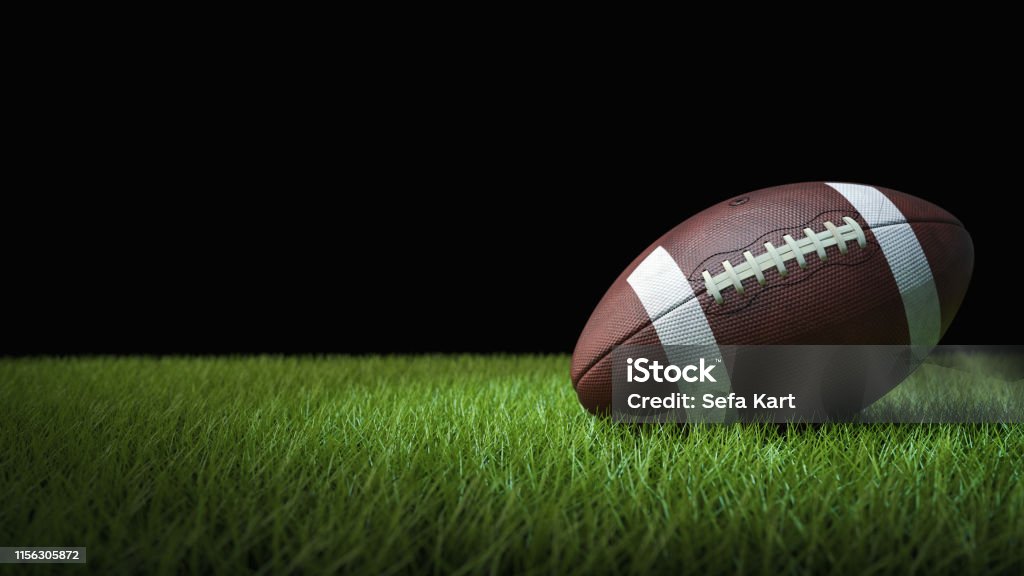 Futebol americano na grama verde, no fundo preto - Foto de stock de Bola de Futebol royalty-free