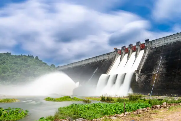 Photo of Long exposure photo of water release at spillway or overflows at big dam with blue sky and clouds (Khun Dan Prakan Chon dam in Nakhon Nayok province Thailand)