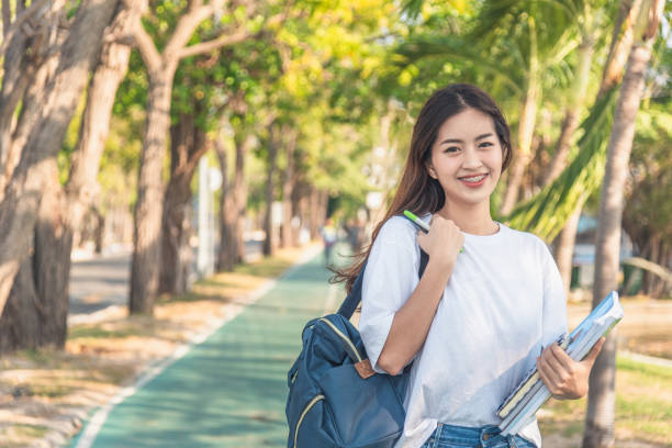 istock A female college student reading a book while lying on the park 1156307215