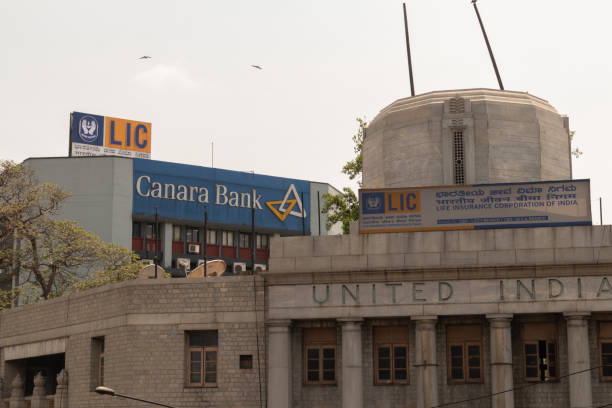 lic ou société d'assurance-vie de l'inde et canara panneau d'affichage de banque sur le dessus du bâtiment à bengaluru, inde - bangalore india business building exterior photos et images de collection