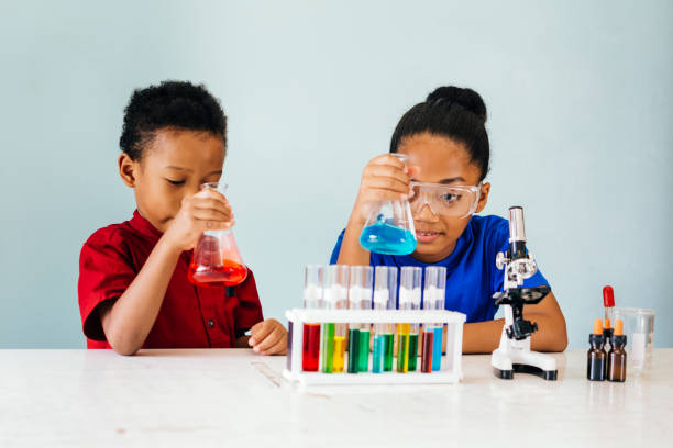 crianças pretas curiosas que experimentam no laboratório da química da escola - colors liquid small laboratory - fotografias e filmes do acervo