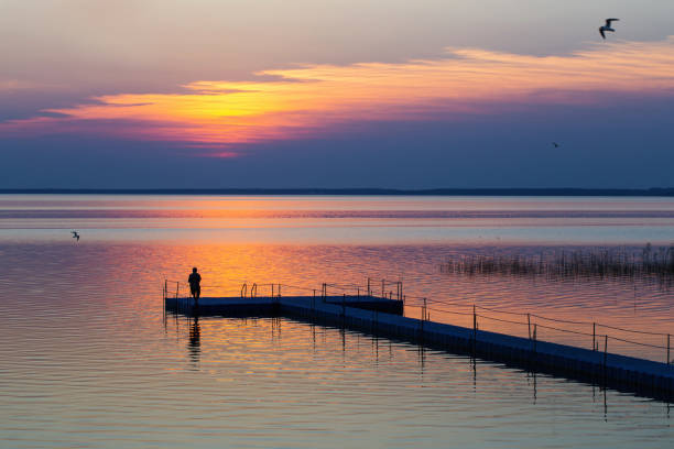 istock men on pontoon pier at sunset 1156314488