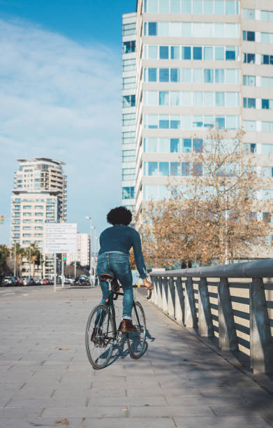 istock Man with afro hair riding a vintage style bicycle 1156316625