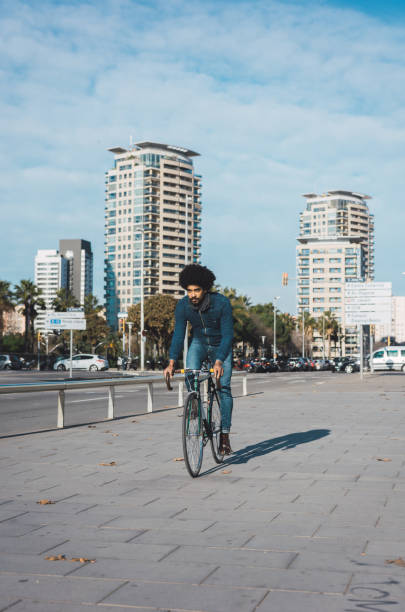 istock Man with afro hair riding a vintage style bicycle 1156316629