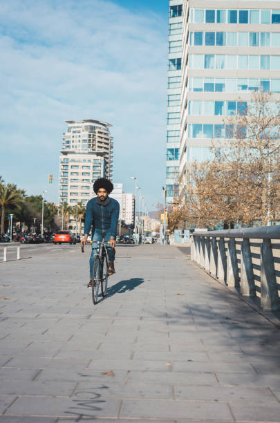 istock Man with afro hair riding a vintage style bicycle 1156316631