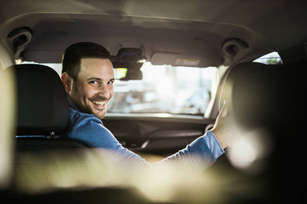 homem feliz novo que estaciona seu carro em um reverso. - car driving men reversing - fotografias e filmes do acervo