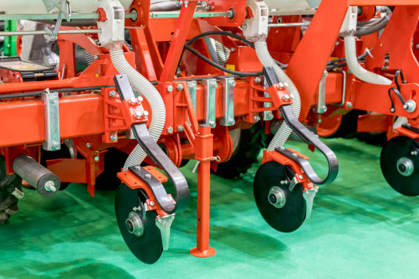 istock Plow modern tech red tractor close up on an agricultural field. Mechanism. Precision inline seeder. A row seeder. Seed drill. Fragment. 1156318746