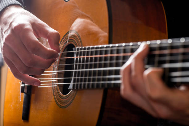 istock adult white guy playing an acoustic guitar. Backlit shooting 1156319890