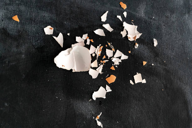 istock cracked egg shell isolated on dark background, ingredients for cookings 1156320981