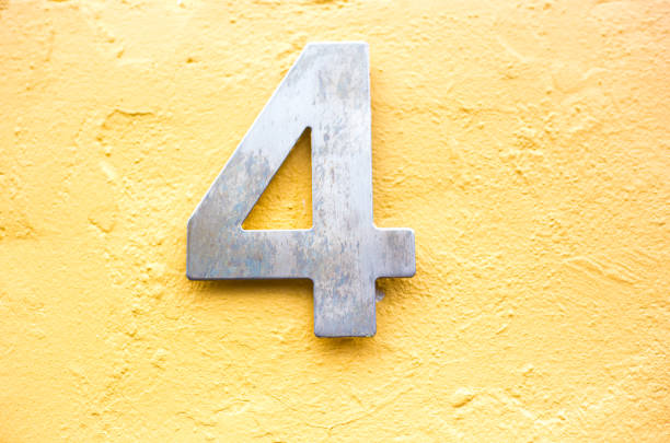 istock Metal Number 4 on Vibrant Yellow Wall 1156325596