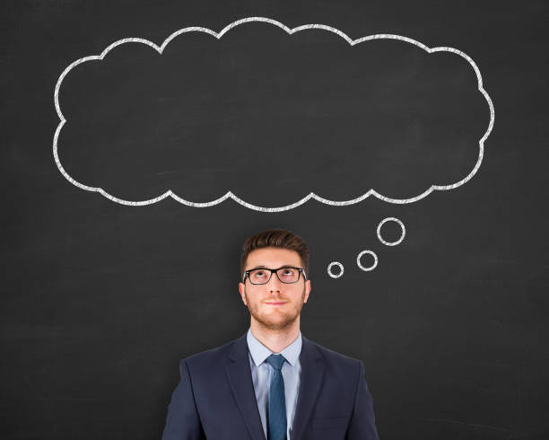 istock Business man standing next to thought bubble drawn on chalkboard 1156326294
