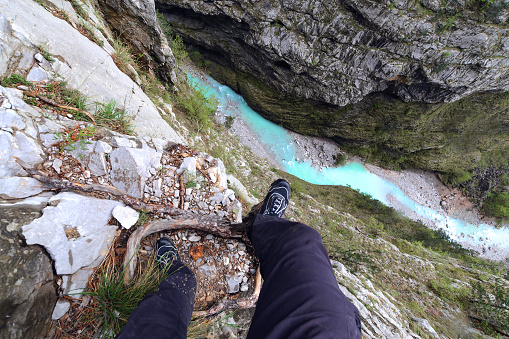 Tourist's feet on a precipice, area of Villanova. Belluno. Italy