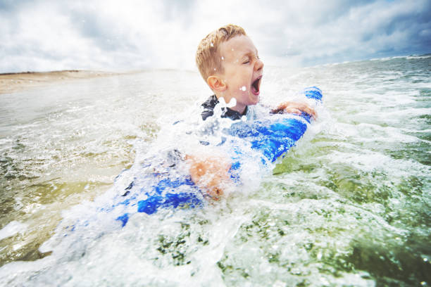 istock Little boy bodyboarding at the sea 1156327847