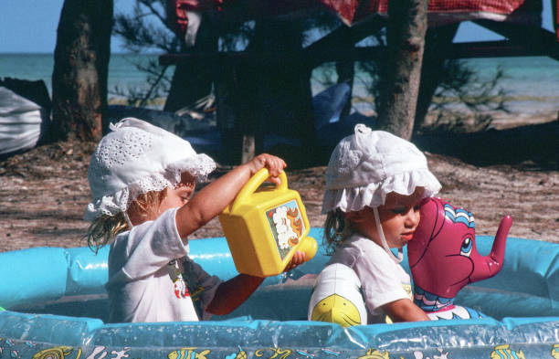 istock Two toddlers sitting in an inflatable pool 1156328643