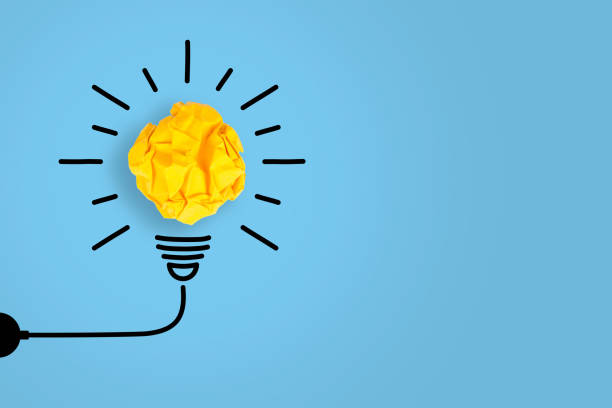 istock Idea Concepts Light Bulb Crumpled Yellow Paper on Blue Background 1156328645