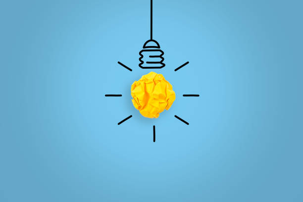 istock Creative Idea Concepts Light Bulb Crumpled Yellow Paper on Blue Background 1156328697