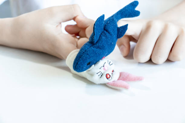 istock A caucasian boy playing different roles by using finger puppets, toys for expressing his emotions, agression, fear and freandship as a part of psychotherapy 1156328816
