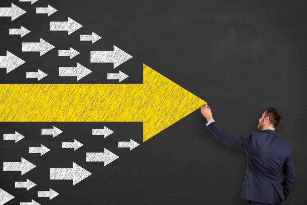 istock Business Person Drawing Leadership Concepts with Arrows on Chalkboard Background 1156329068